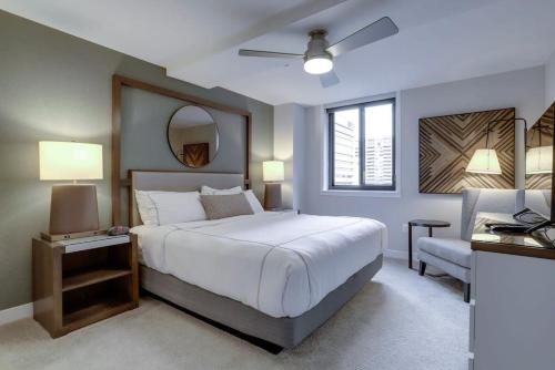 een slaapkamer met een groot wit bed en een stoel bij Sojourn Courtland Towers 2 BR in Arlington