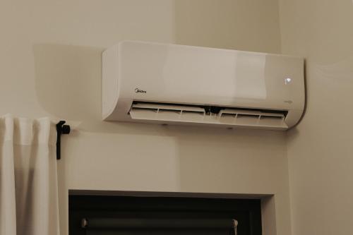 a air conditioner hanging on a wall above a fireplace at Light house in Cēsis