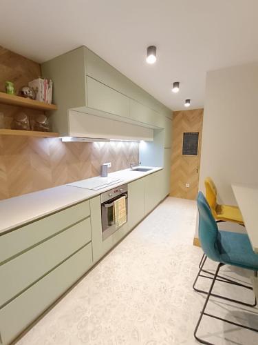 une cuisine avec une table et une chaise bleue dans l'établissement Grande Maison familiale proche de Lyon 7 personnes, à Dommartin