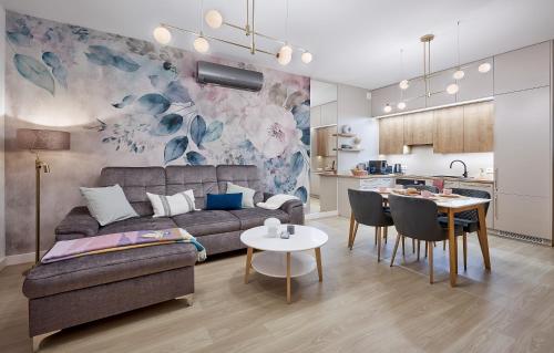 una sala de estar con un sofá y una mesa en Boszkowo Horizon Park Apartament 36 "Kwiecisty sen", en Boszkowo