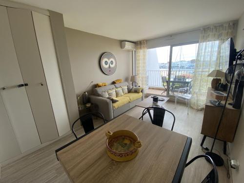 un salon avec une table et un canapé dans l'établissement Sol-y-Days Santa Maria vue sur les marinas, au Grau-du-Roi