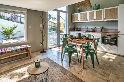une cuisine avec une table et des chaises dans une pièce dans l'établissement Cottage Petit Piladi, à Lacanau