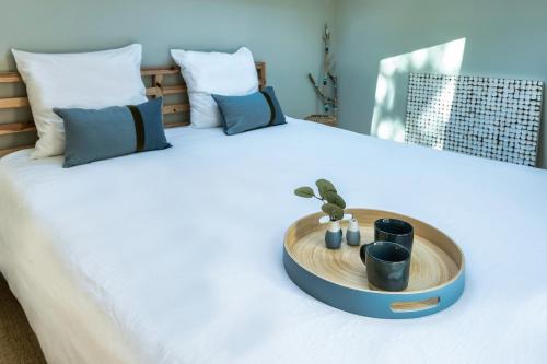 - un lit avec un plateau en bois recouvert d'une plante dans l'établissement Cottage Petit Piladi, à Lacanau