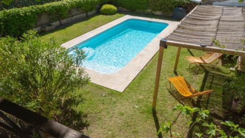 une piscine dans une cour avec une table et des chaises dans l'établissement Au pied du Luberon, à Les Taillades