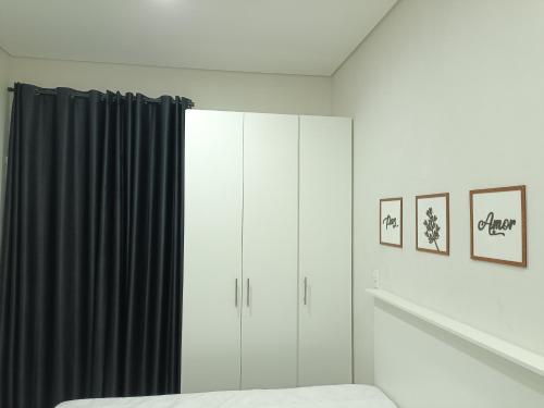 a bedroom with white cabinets and black curtains at Cantinho da Paz in Sao Paulo