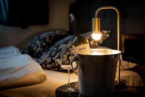 a bottle of wine in a bucket next to a wine glass at Great Polonia Dwarf Wrocław in Wrocław