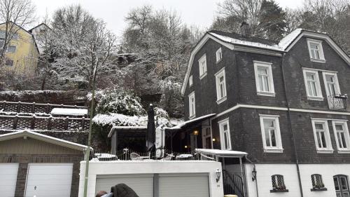a man standing in front of a house in the snow at Villa Burgau, C&H in Monschau