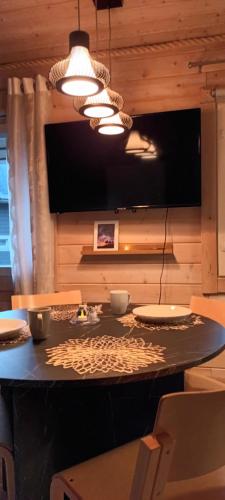 a dining room with a table and a tv at Villa in Kalajoki