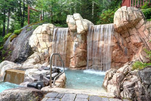 a waterfall in a pool of water with rocks at Tremblant Prestige - Les Eaux 233-3 in Mont-Tremblant