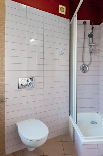 a white bathroom with a toilet and a shower at Great Polonia Dwarf Wrocław in Wrocław