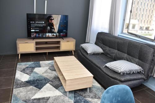 a living room with a couch and a tv at 305 Urban Oasis in Jozi CBD in Johannesburg