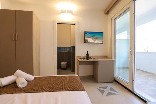 una camera con letto e scrivania e un bagno di The Square Castelsardo a Castelsardo