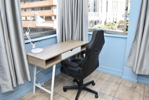 a desk with a chair in front of a window at 305 Urban Oasis in Jozi CBD in Johannesburg