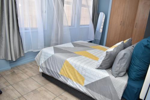 a bedroom with a bed with a quilt on it at 305 Urban Oasis in Jozi CBD in Johannesburg