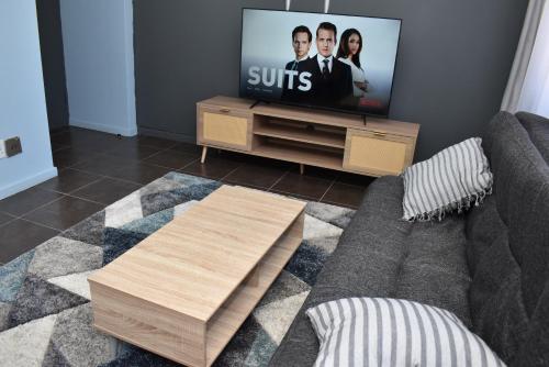 a living room with a couch and a flat screen tv at 305 Urban Oasis in Jozi CBD in Johannesburg