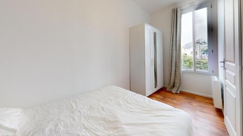 une chambre blanche avec un lit et une fenêtre dans l'établissement F1 bis - Garibaldi, au Havre