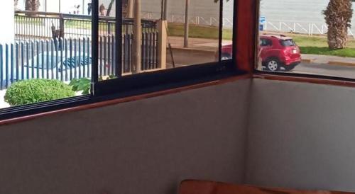 a room with a window with a red car in a parking lot at Bellavista in Lima