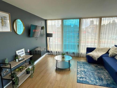 a living room with a blue couch and a table at Stay Angels - Blonk Street Sheffield Luxury Apartments in Sheffield