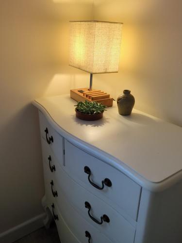 a lamp on top of a dresser with a lamp on it at Woodstock Studio in Woodstock