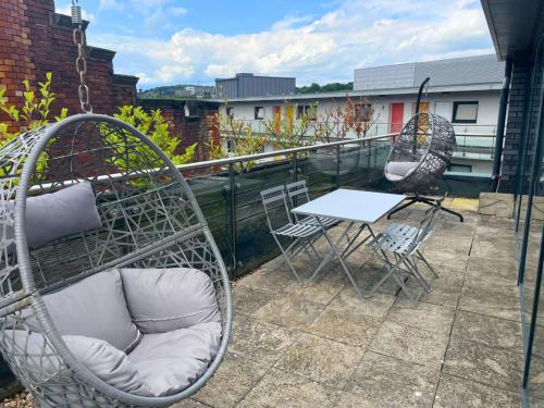 a patio with two chairs and a table on a balcony at Stay Angels - Blonk Street Sheffield Luxury Apartments in Sheffield