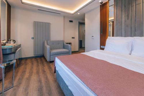 a hotel room with a large bed and a chair at VE Hotels Adakale in Yenişehir