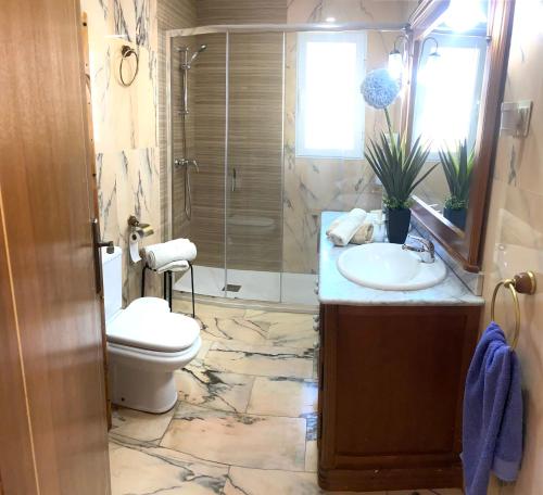 Un baño con lavabo, inodoro y ducha. en VILLA HUETOR , Piscina y barbacoa privada, en Huétor Vega