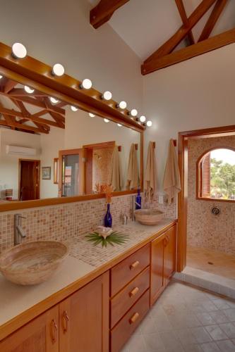 a bathroom with two sinks and a large mirror at Naïa Resort and Spa in Placencia Village