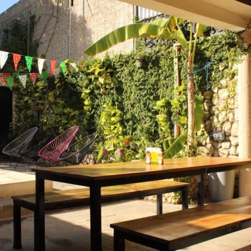a wooden bench sitting in front of a green wall at VALLADOLID 48 Hotel & Hostal in Valladolid