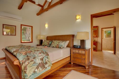 a bedroom with a bed and a dresser with a night stand at Naïa Resort and Spa in Placencia Village