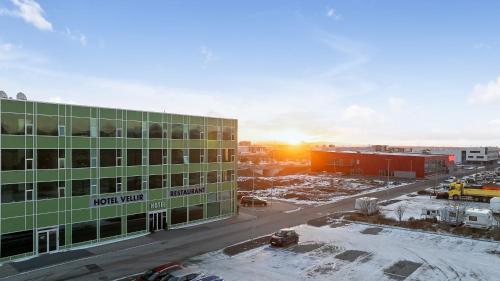 a view of a building with the sunset in the background at Hotel Vellir in Hafnarfjördur