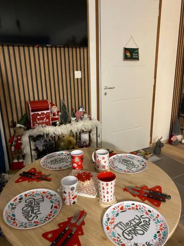 une table avec des assiettes et des tasses en haut dans l'établissement La maison de Noel et ses lutins, à Calais