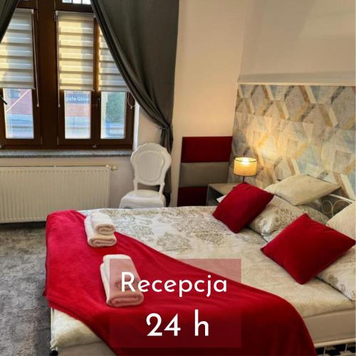 a bedroom with a large bed with red pillows at AmaMolto Train Station in Opole