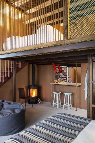 a room with a loft bed and a fireplace at Noah Surf House Portugal in Santa Cruz