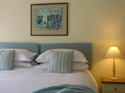 a bedroom with a bed with pillows and a picture on the wall at Mains of Orton in Fochabers