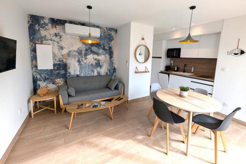 a living room with a couch and a table at DAYA LODGE. in LʼIsle-sur-la-Sorgue