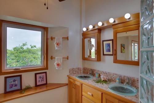 a bathroom with two sinks and two mirrors at Naïa Resort and Spa in Placencia Village