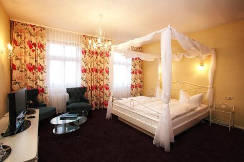 a bedroom with a bed with a canopy at Hotel zur Insel in Werder