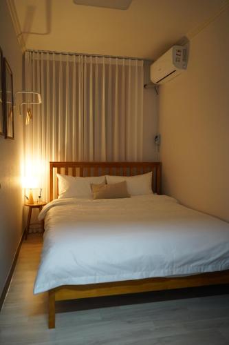 a bedroom with a large white bed in a room at Busan Subway 6min #2 Rooms #2 Queen Beds #Hotel Bedding #OTT #Table#1st Floor in Busan