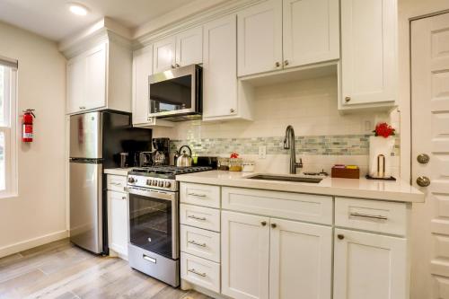 a kitchen with white cabinets and stainless steel appliances at Naïa Resort and Spa in Placencia Village
