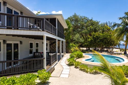 a house with a swimming pool and a balcony at Naïa Resort and Spa in Placencia Village