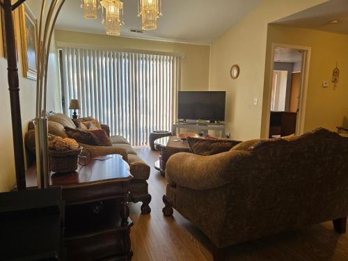 a living room with couches and a flat screen tv at Entire 2-bedroom, 2 bath home with parking and newly renovated floors in Canton