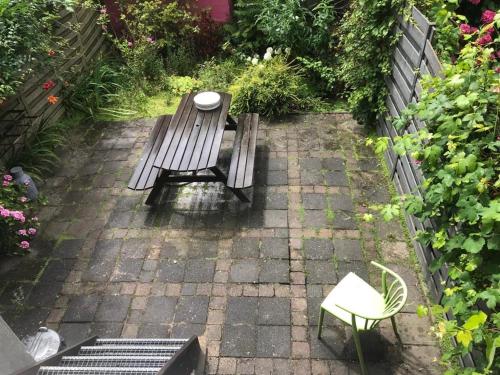 a picnic table and a bench in a garden at Appartement Rotterdam Noord in Rotterdam