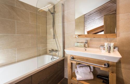 a bathroom with a sink and a shower and a tub at Hôtel Saint Charles Val Cenis in Lanslebourg-Mont-Cenis