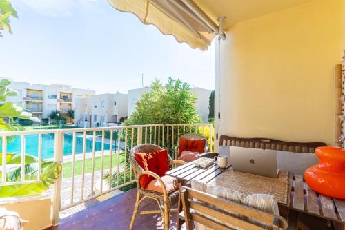 Un balcón con una mesa y una computadora portátil encima. en TrendyHomes Retamar III - Playa, piscina y golf, en Almería