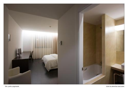 a bedroom with a bed and a desk and a bathroom at ETH Rioja in Haro