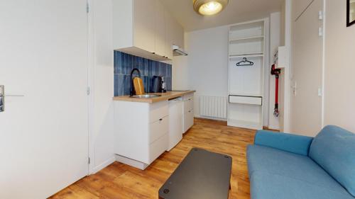 un salon avec un canapé bleu et une cuisine dans l'établissement Joli studio rue garibaldi, au Havre