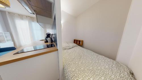 - une petite cuisine avec un lit dans une chambre dans l'établissement Joli studio rue garibaldi, au Havre