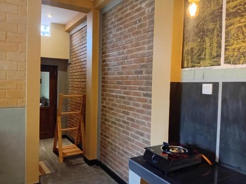una habitación con una pared de ladrillos y una estufa en Liyans Eco Villa, en Habaraduwa Central