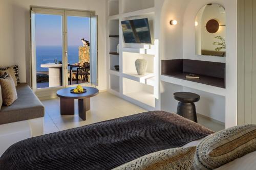 a bedroom with a bed and a view of the ocean at Seascape Suites Folegandros in Ano Meria