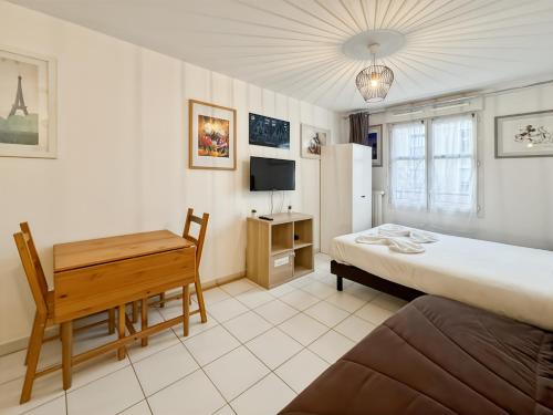 une chambre avec un lit, un bureau et une télévision dans l'établissement Scandinaves 21 - Studio pour 4 à Disneyland Paris, à Serris